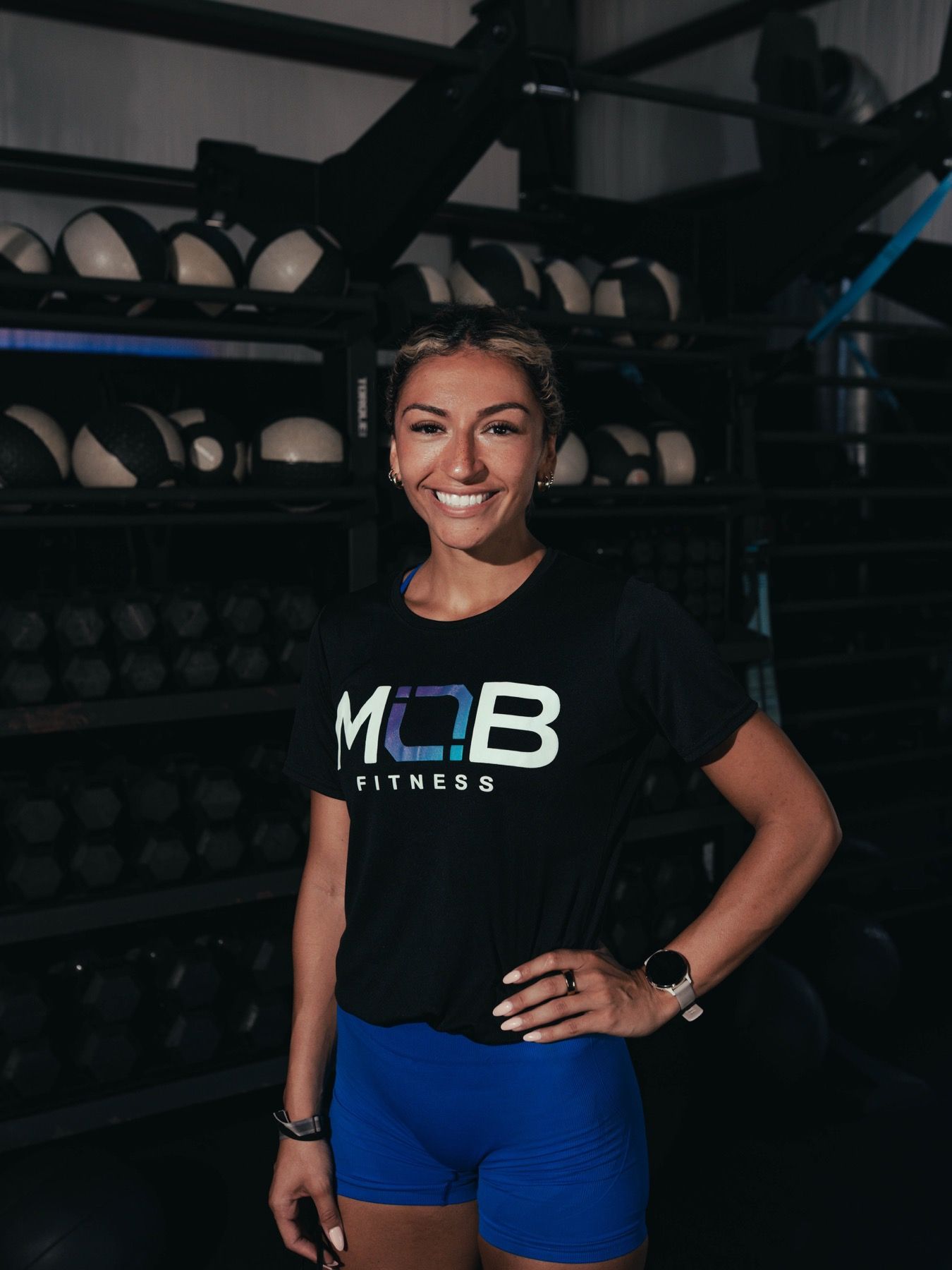 A smiling MOB Fitness coach on the gym floor